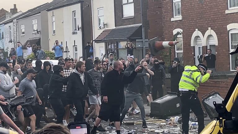 Una multitud descontrolada se enfrenta a la policía, el martes 30 de julio de 2024, en Southport, en el noroeste de Inglaterra, cerca de donde tres chicas murieron apuñaladas en una clase de baile el día anterior.