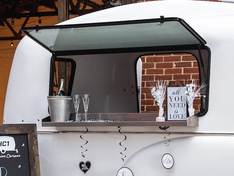 A trailer being used as a bar at a wedding.
