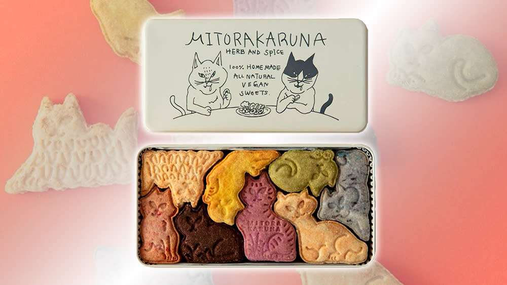  An image of a tin of cookies in the shape of cats. 