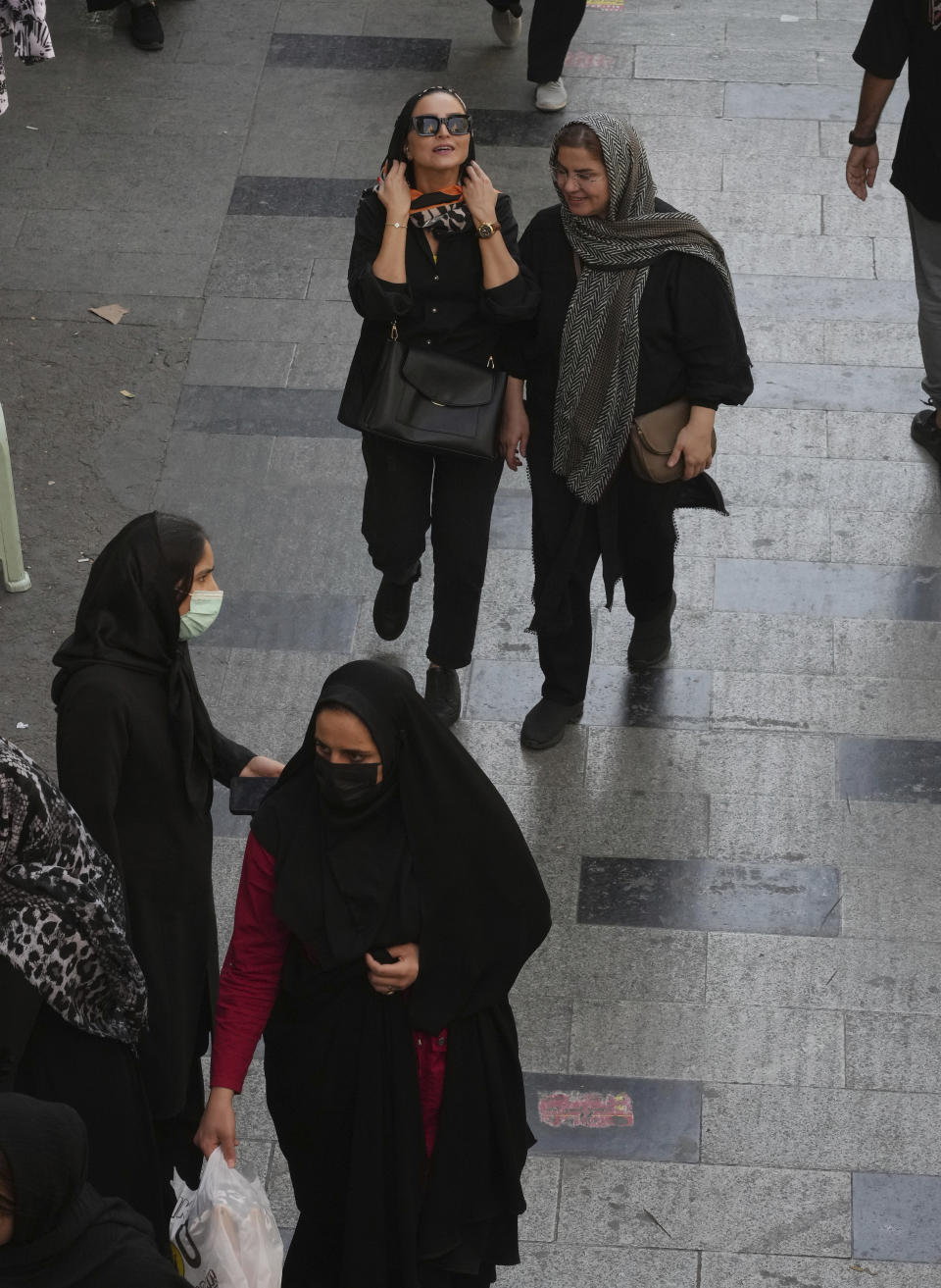 Women walk around in the old main bazaar of Tehran, Iran, Saturday, Oct. 1, 2022. Thousands of Iranians have taken to the streets over the last two weeks to protest the death of Mahsa Amini, a 22-year-old woman who had been detained by the morality police in the capital of Tehran for allegedly wearing her mandatory Islamic veil too loosely. (AP Photo/Vahid Salemi)