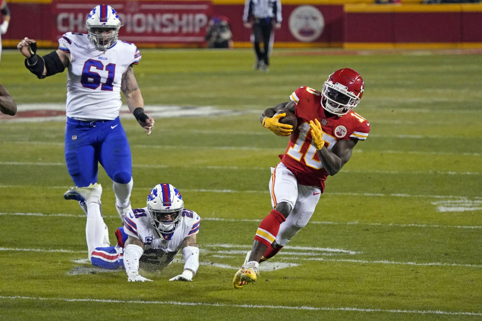 El receptor Tyrel Hill de los Chiefs de Kansas City corre con el balón el domingo 24 de enero del 2021 mientras lo intentan detener el safety Jordan Poyer y el tacle defensivo Justin Zimmer de los Bills de Búfalo en el duelo por el campeonato de la AFC. (AP Foto/Jeff Roberson)