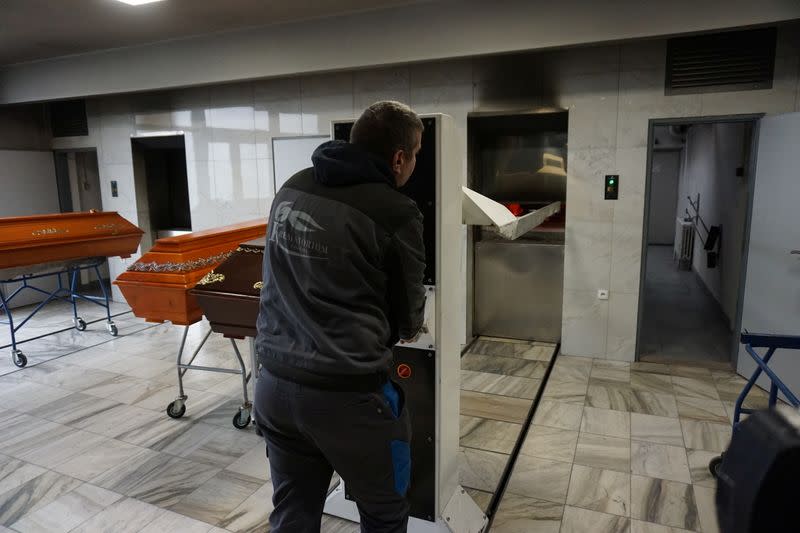 A crematorium employee stands next to the coffins with people who passed away due to coronavirus disease (COVID-19) at crematory in Ostrava