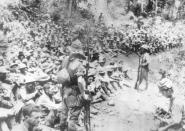 FILE - In this 1942, file photo provided by U.S. Marine Corps, Japanese soldiers stand guard over American war prisoners just before the start of the Bataan Death March following the Japanese occupation of the Philippines. Japan’s unpreparedness for the large number of captives, coupled with disdain for surrendering troops, led to extensive brutality during the forced march, remembered as one of worst atrocities of World War II. (U.S. Marine Corps via AP, File)