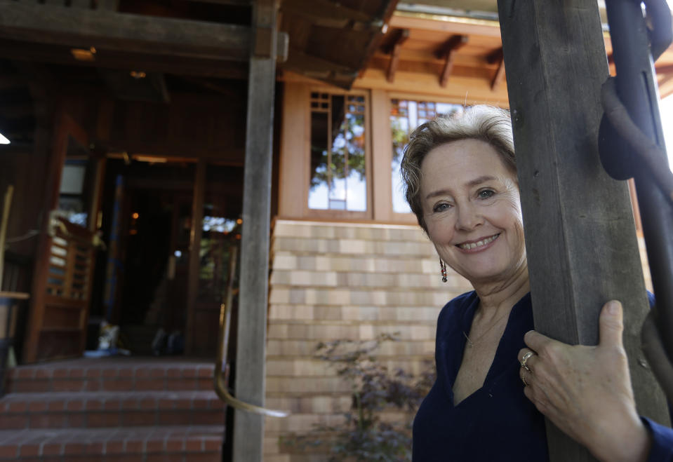 In this photo taken Thursday, June 20, 2013 Alice Waters poses outside the new front entrance to her Chez Panisse restaurant in Berkeley, Calif. After a fire in March shut the doors to the famous gourmet restaurant, the eatery is preparing to reopen June 24. (AP Photo/Eric Risberg)