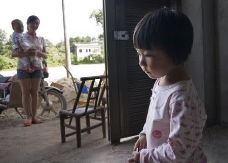 File photo of two-year-old Xu Yilin, whose blood, according to her family, has been shown to have almost three times the national limit for lead exposure in children, stands in a neighbor's house in Dapu town, Hunan province, June 25, 2014. REUTERS/Alexandra Harney