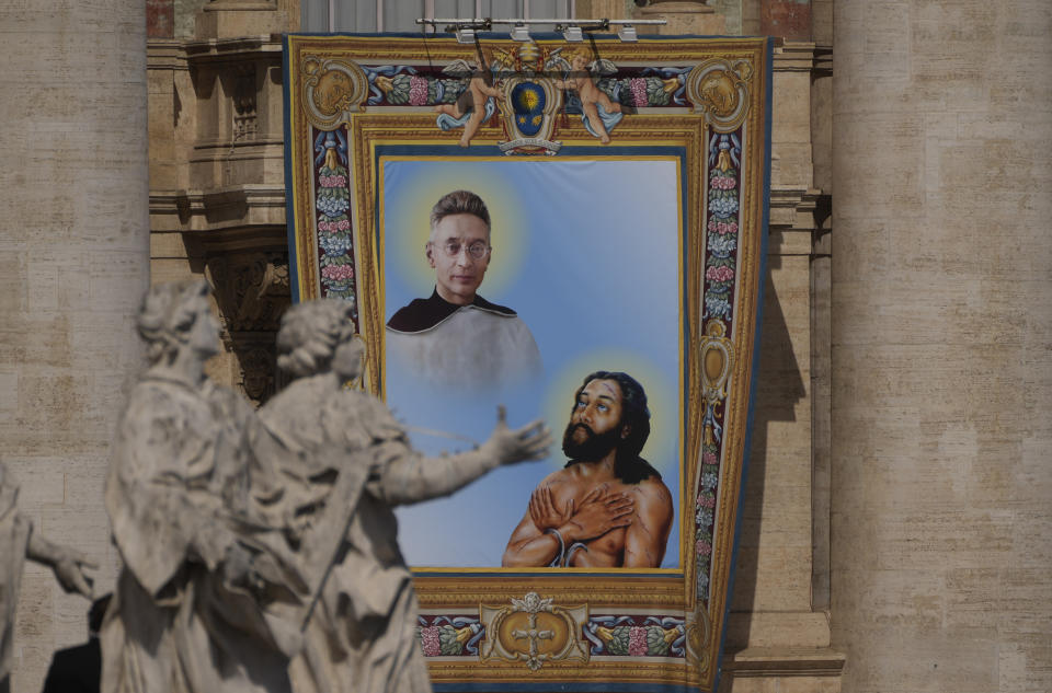 The tapestry depicting Titus Brandsma (1881-1942), top, and Lazzaro alias Devasahayam (1712-1752) hangs in St. Peter's Square at The Vatican, Sunday, May 15, 2022, during their canonization mass celebrated by Pope Francis. Francis created ten new saints on Sunday, rallying from knee pain that has forced him to use a wheelchair to preside over the first canonization ceremony at the Vatican in over two years. (AP Photo/Gregorio Borgia)