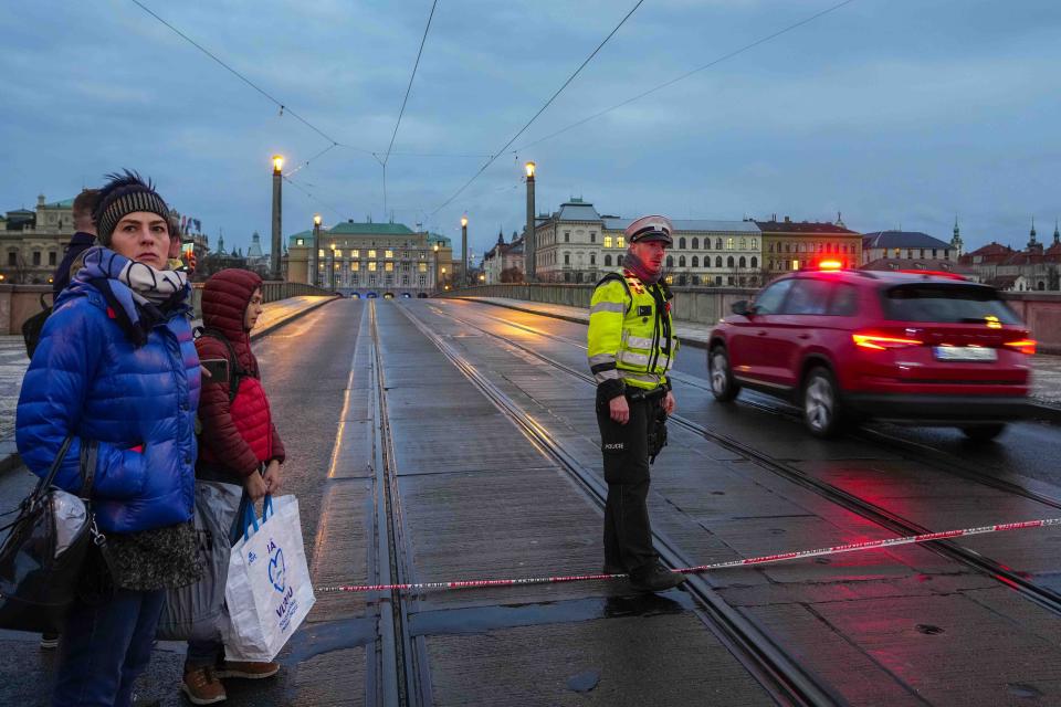 A police officer guards a street after a shooting in downtown Prague, Czech Republic, Thursday, Dec. 21, 2023. Czech police say a shooting in downtown Prague has killed an unspecified number of people and wounded others. (AP Photo/Petr David Josek)