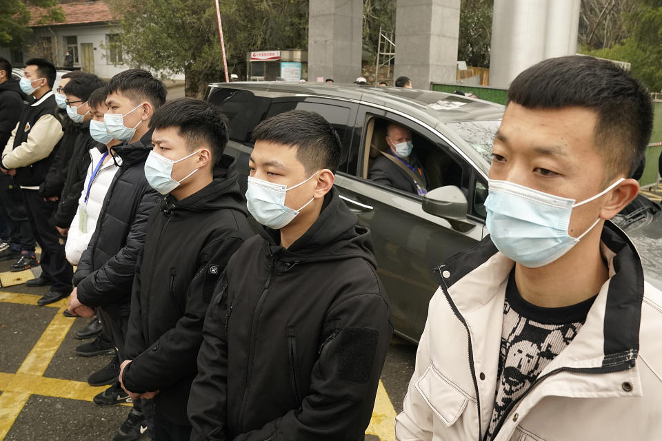 Peter Daszak of the World Health Organization leaves in a car past a row of security personnel at the Hubei Center for Disease Control and Prevention after a field visit in Wuhan in central China's Hubei province on Monday, Feb. 1, 2021. (AP Photo/Ng Han Guan)