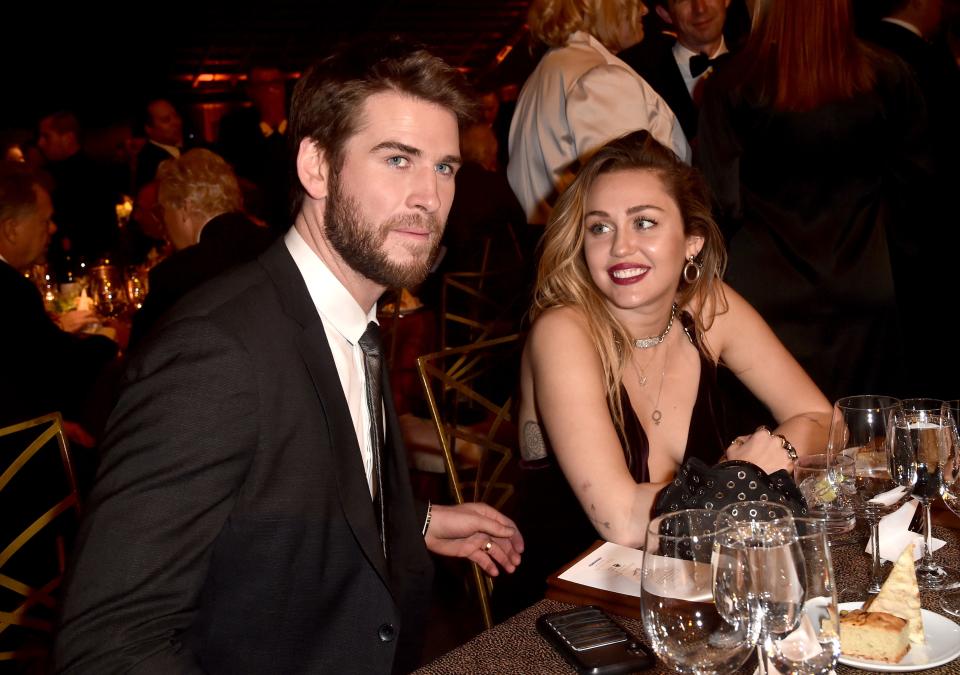 Miley Cyrus and Liam Hemsworth at a table