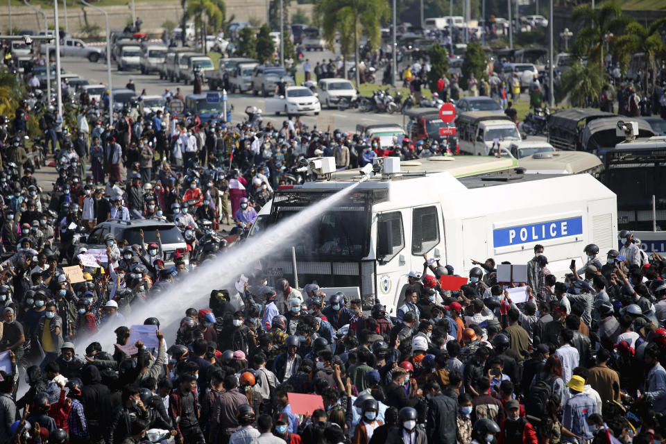 A police truck uses a water cannon to disperse a crowd of protesters in Naypyitaw, Myanmar on Monday, Feb. 8, 2021. Tension in the confrontations between the authorities and demonstrators against last week's coup in Myanmar boiled over Monday, as police fired a water cannon at peaceful protesters in the capital Naypyitaw. (AP Photo)