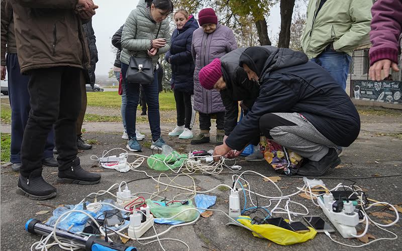 People charge their phones on central square in Kherson, Ukraine