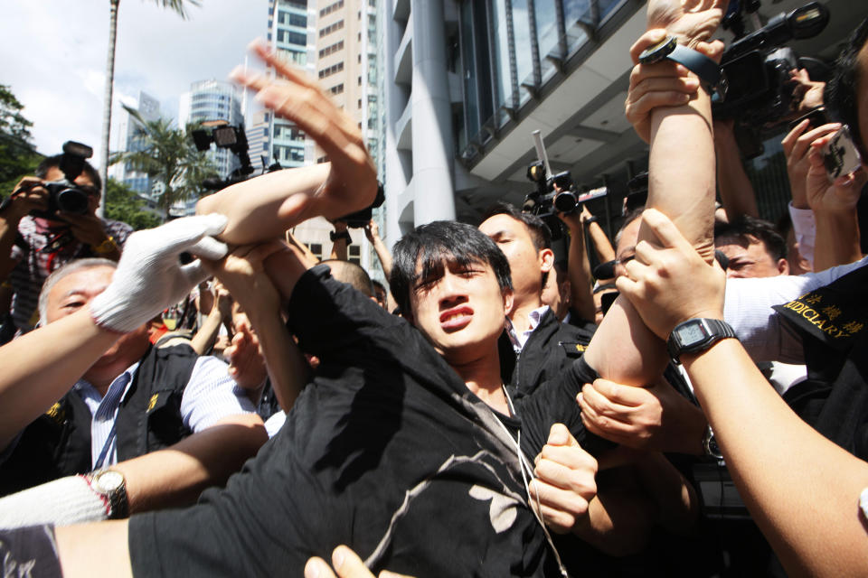 Bailiffs carry a protester away from a public space underneath HSBC's Asian headquarters in Hong Kong, Tuesday, Sept. 11, 2012. Hong Kong's Occupy activists were locked in a standoff Tuesday with bailiffs trying to evict them from the site. (AP Photo/Kin Cheung)