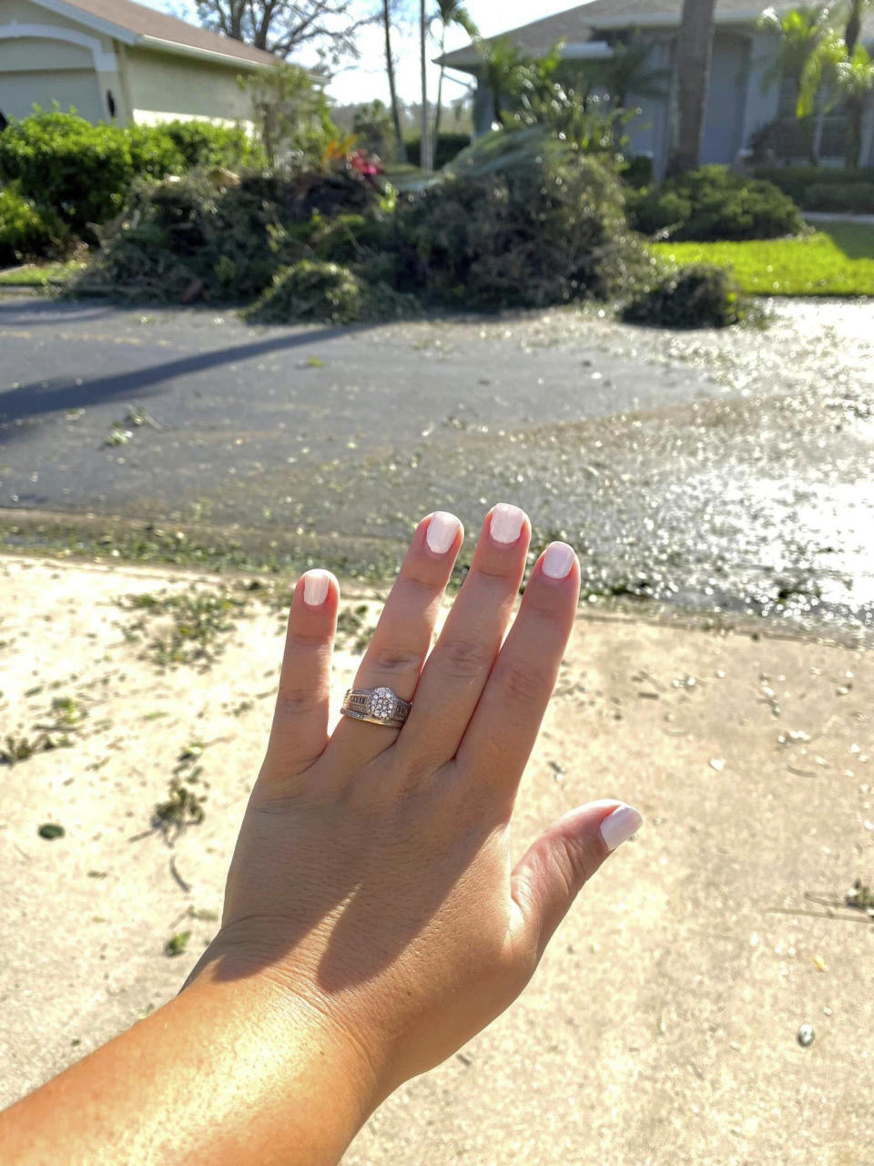 In this undated photo provided by Ashley Garner, Garner shows off her wedding ring that was found lying in a brush pile after Hurricane Ian passed through the area, in Fort Myers, Fla. (Ashley Garner via AP)