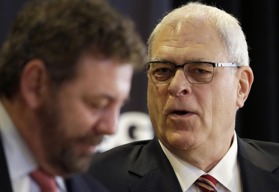 James Dolan, left, executive chairman of Madison Square Garden, listens to Phil Jackson at a news conference where Jackson was named as the new president of the New York Knicks, Tuesday, March 18, 2014 in New York. Jackson, who won two NBA titles as a player for the New York Knicks, also won 11 championships while coaching the Chicago Bulls and the Los Angeles Lakers. (AP Photo/Mark Lennihan)