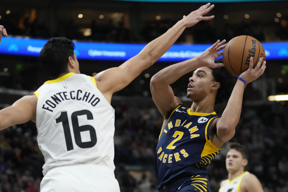 Indiana Pacers guard Andrew Nembhard (2) goes to the basket as Utah Jazz forward Simone Fontecchio (16) defends during the first half of an NBA basketball game Friday, Dec. 2, 2022, in Salt Lake City. (AP Photo/Rick Bowmer)