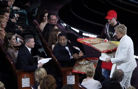 Show host Ellen DeGeneres delivers pizza to the audience at the 86th Academy Awards in Hollywood, California March 2, 2014. REUTERS/Lucy Nicholson