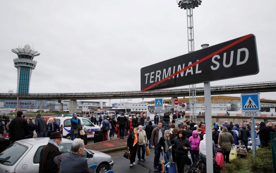 Passengers wait at Orly airport southern terminal after a shooting incident near Paris - Credit: Reuters