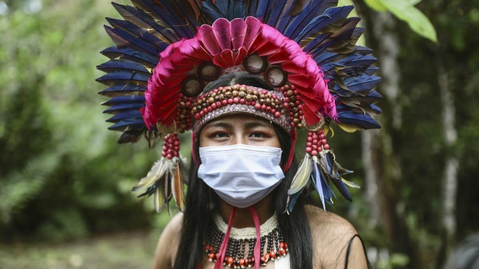 Joven en Leticia, Colombia, con ropas típicas y corona de plumas