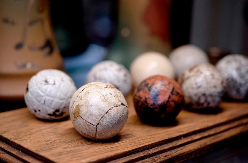 An Allan Robertson feather golf ball, front, is part of a display of the evolution of golf balls at the Old Golf Shop on Worth Avenue.