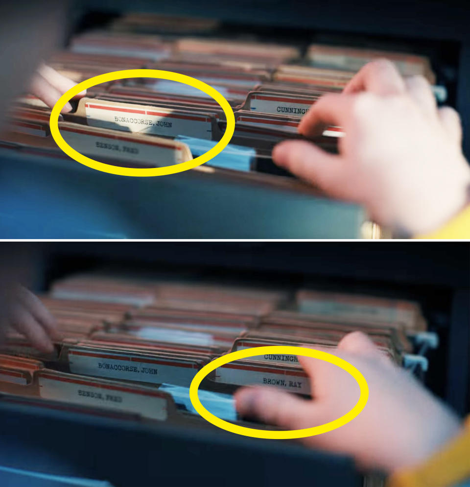 person's hands looking through a file cabinet