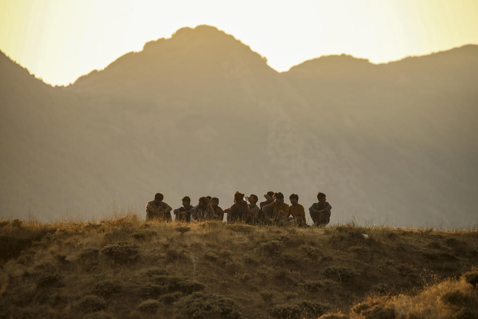 Young men who say they deserted the Afghan military and fled to Turkey through Iran sit in the countryside in Tatvan, in Bitlis Province in eastern Turkey, Tuesday, Aug. 17, 2021. Turkey is concerned about increased migration across the Turkish-Iranian border as Afghans flee the Taliban advance in their country.(AP Photo/Emrah Gurel)