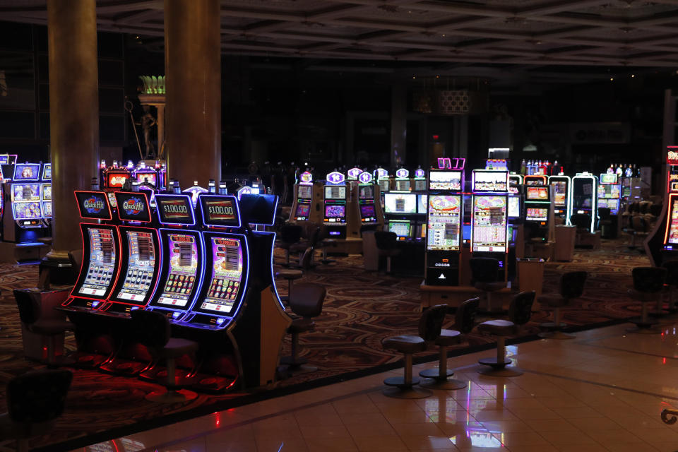 Chairs have been removed at some electronic slot machines to maintain social distancing between players at a closed Caesars Palace hotel and casino Thursday, May 21, 2020, in Las Vegas. Casino operators in Las Vegas are awaiting word when they will be able to reopen after a shutdown during the coronavirus outbreak. (AP Photo/John Locher)