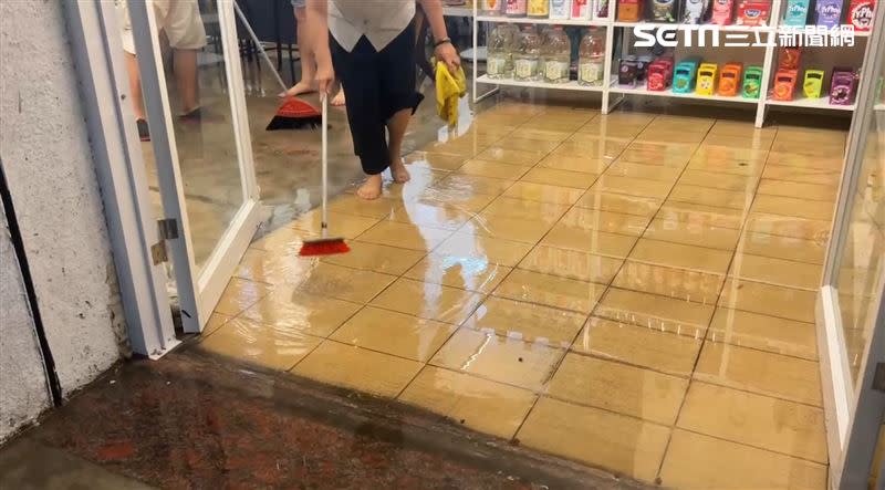 水淹入開山路店家，店員忙著把水往外掃。（圖／翻攝畫面）