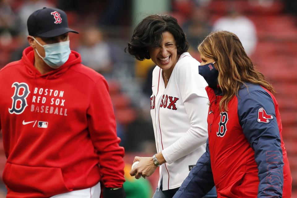 Director of the Centers for Disease Control and Prevention Rochelle Walensky, center, walks off the field after throwing out the ceremonial first pitch to Boston Red Sox's Christian Vazquez, left, before a baseball game against the Miami Marlins, Saturday, May 29, 2021, in Boston. (AP Photo/Michael Dwyer)