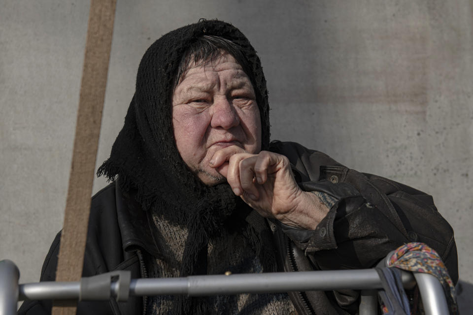 Olga Lehan, 71, stands in a yard of her house in the village of Demydiv, about 40 kilometers (24 miles) north of Kyiv, Ukraine, Tuesday, Nov. 2, 2022. Olga Lehan's home near the Irpin River was flooded when Ukraine destroyed a dam to prevent Russian forces from storming the capital of Kyiv just days into the war. Weeks later, the water from her tap turned brown from pollution. (AP Photo/Andrew Kravchenko)