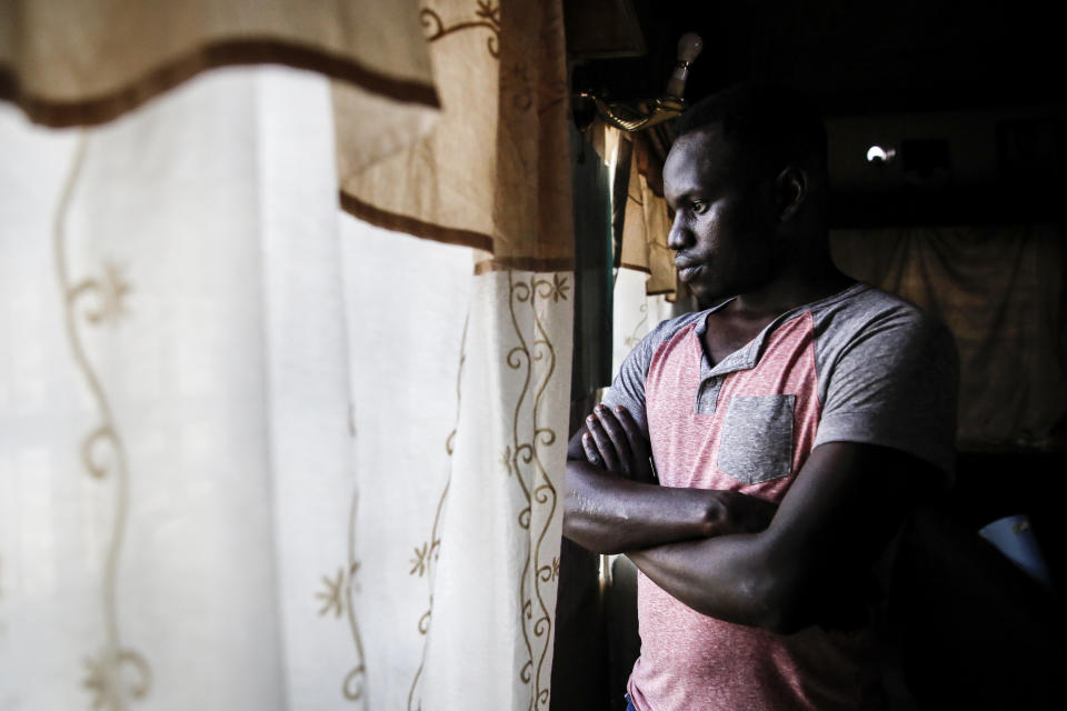 In this photo taken Thursday, June 11, 2020, Martin Okello looks out of the window in the house he shares with other Ugandan LGBT refugees in Nairobi, Kenya. He and other members of the LGBT community in East Africa face discrimination that has forced many to flee their home countries for Kenya, which has become a haven for them. It is the only East African nation where someone can seek asylum and be registered as a refugee based on their LGBT status. Yet even in Kenya, they can be encounter discrimination and violence, and the country still criminalizes gay sex. (AP Photo/Brian Inganga)