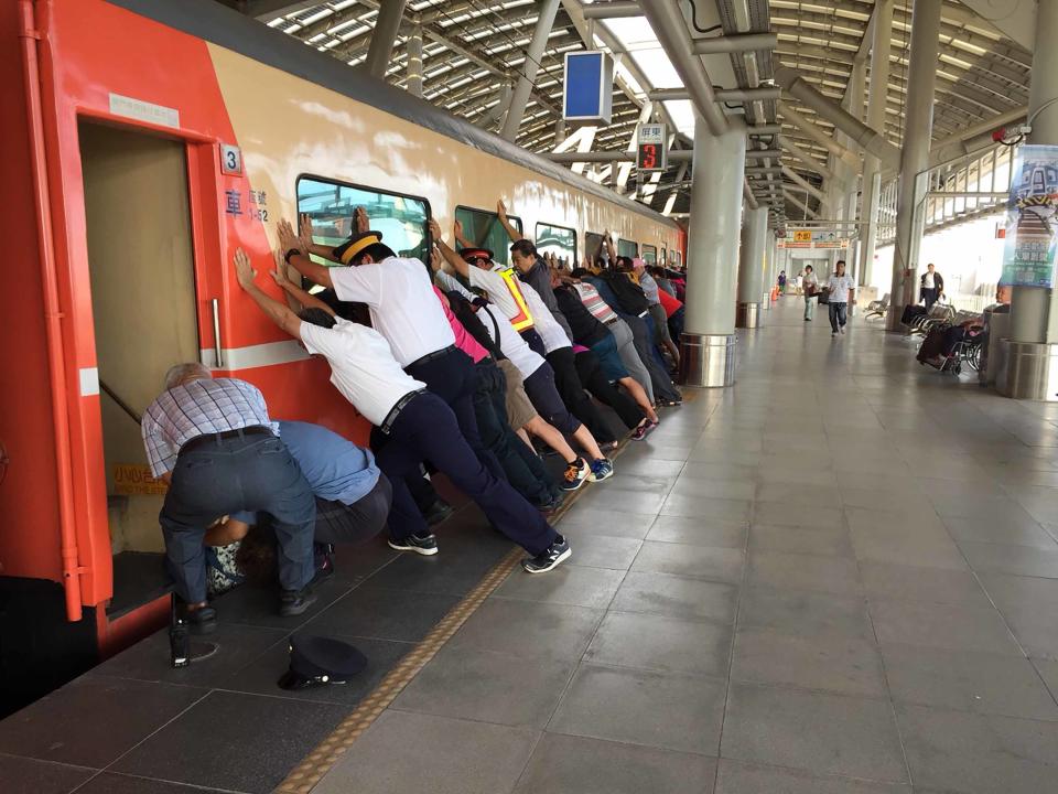 27日上午有一名女性旅客在台鐵屏東站，強行上已啟動的列車，結果卡在月台與車廂間，列車緊急停駛，台鐵工作人員與月台上其他旅客合力推車廂救人。（中央社／台鐵提供）