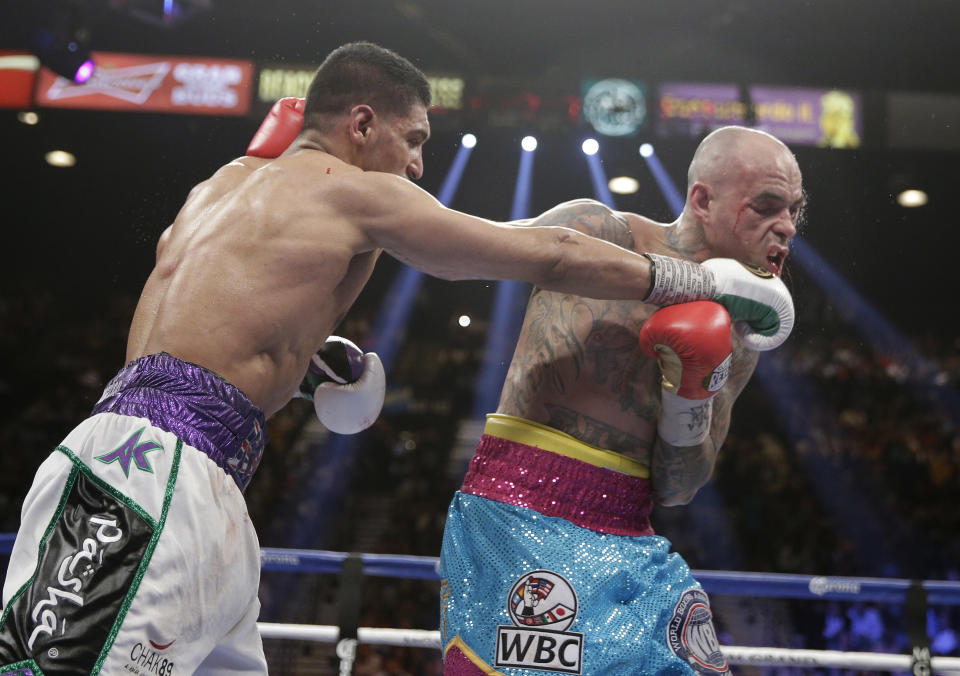 England's Amir Khan, left, lands a right against Luis Collazo in their silver welterweight title boxing fight Saturday, May 3, 2014, in Las Vegas. (AP Photo/Isaac Brekken)