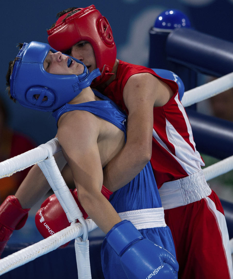 In this photo provided by the International Olympic Committee, Maksym Halinichev of Ukraine, left, and Abdumalik Khalokov of Uzbekistan compete in the Boxing Men's Bantam (56kg) Gold Medal Bout at the Oceania Pavilion of Youth Olympic Park during the Youth Olympic Games in Buenos Aires, Thursday, Oct. 18, 2018. In May 2022, at 21 years old, Halinichev joined the airborne assault troops, according to Ukraine’s Boxing Federation. (Jonathan Nackstrand/IOC via AP)