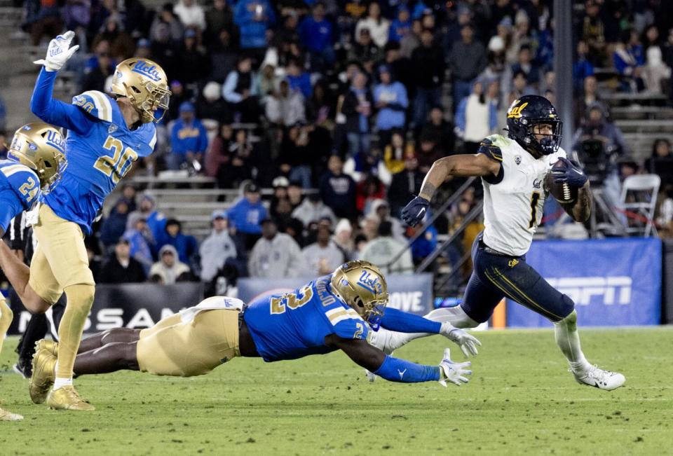 UCLA linebacker Oluwafemi Oladejo leaps toward Jaydn Ott.