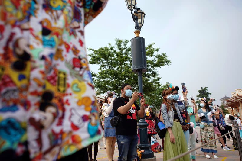 Visitors take pictures at the ceremony marking the reopening of Shanghai Disneyland