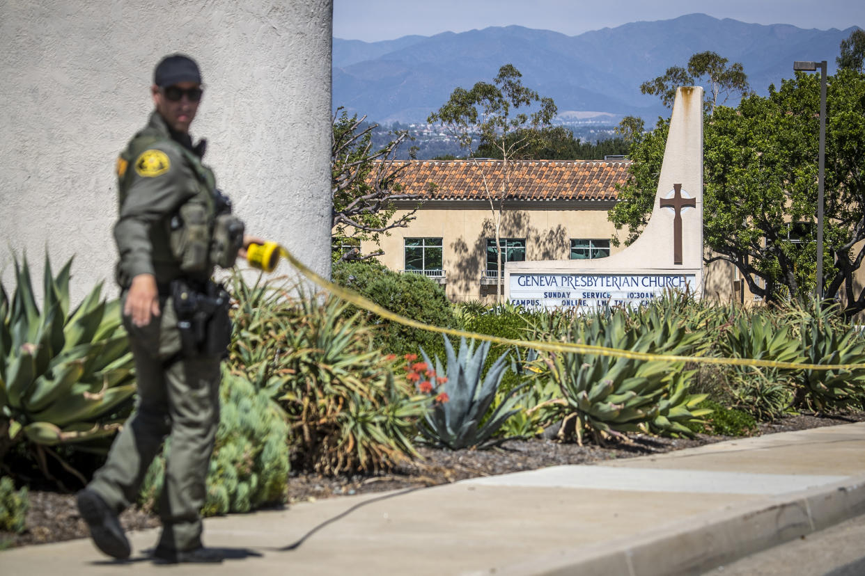 An Orange County Sheriffs Officer places police tape around the exterior of the Geneva Presbyterian Church after a person opened fire during a church service, in Laguna Woods, Calif., on May 15, 2022. (Allen J. Schaben / Los Angeles Times via Getty Images)