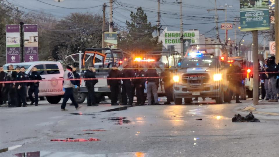 Officers investigate the scene where five suspected hitmen were killed Monday after detectives were ambushed in a residential area in eastern Juárez.