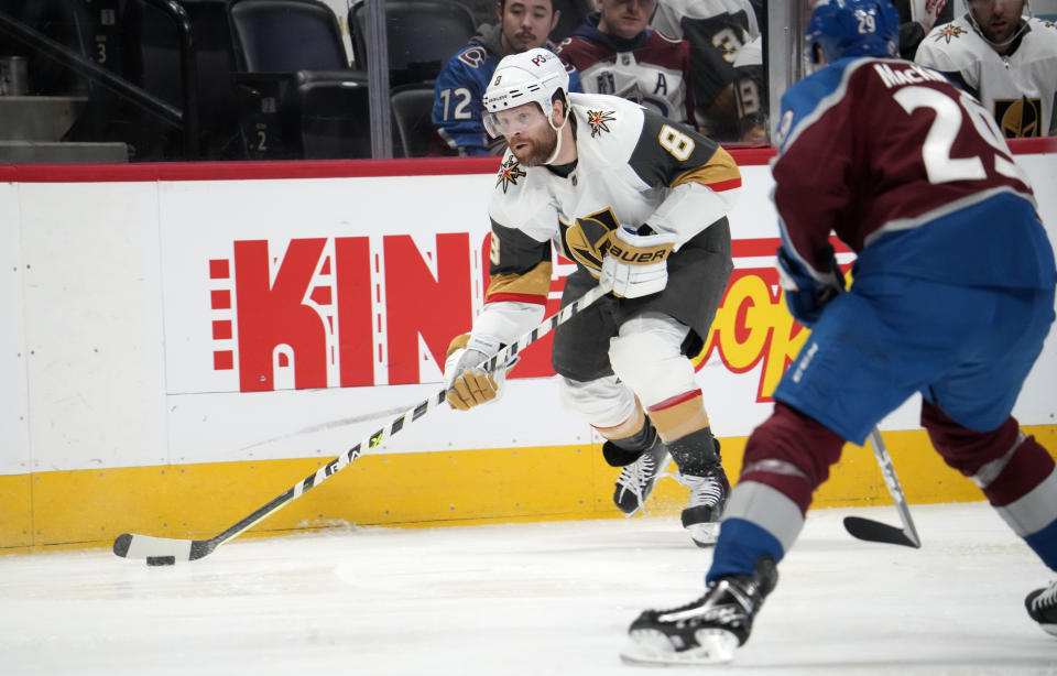 Vegas Golden Knights right wing Phil Kessel, left, shoots as Colorado Avalanche center Nathan MacKinnon, right, defends in the second period of an NHL hockey game Monday, Feb. 27, 2023, in Denver. (AP Photo/David Zalubowski)