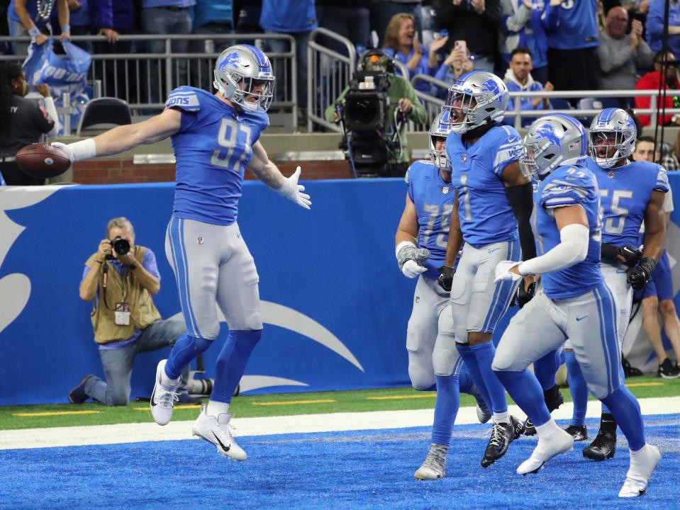 Detroit Lions defensive end Aidan Hutchinson (97) celebrates his interception against the Green Bay Packers during the first half at Ford Field, Nov. 6, 2022.