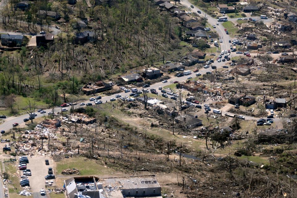 Cars line up along the road as cleanup continues from Friday's tornado damage, Sunday, April 2, 2023, in west Little Rock, Arkansas.