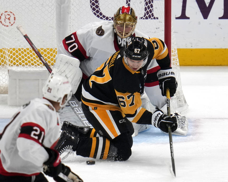 Pittsburgh Penguins' Rickard Rakell (67) cannot get a shot off in front of Ottawa Senators goaltender Joonas Korpisalo (70) during the first period of an NHL hockey game in Pittsburgh, on Saturday, Oct. 28, 2023. (AP Photo/Gene J. Puskar)