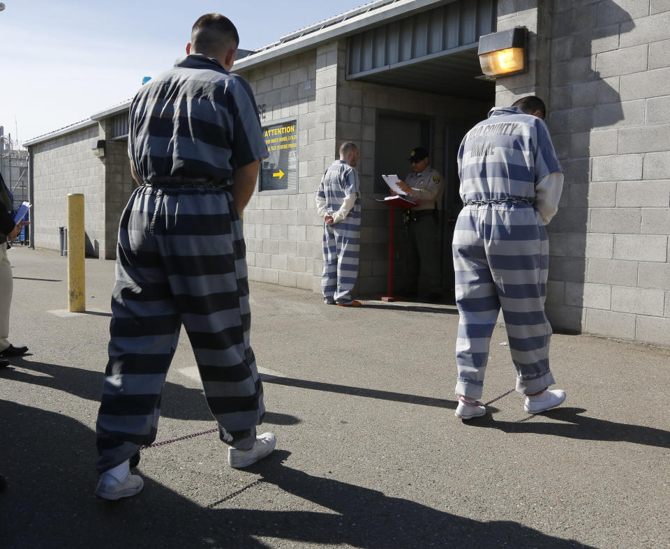 In this photo taken Thursday, Feb. 20, 2014, convicted felons from Yolo County arrive at the Deuel Vocational Institution in Tracy, Calif. California counties are thwarting the state's efforts to comply with a federal court order to reduce it's inmate population by sending state prisons far more convicts than anticipated including a record number of second-strikers. The state is trying to comply with a landmark restructuring of its criminal justice system through a nearly 3-year-old law pushed by Gov. Jerry Brown that keeps lower-level felons in county jails while reserving scarce state prison cells for serious, violent and sexual offenders.(AP Photo/Rich Pedroncelli)