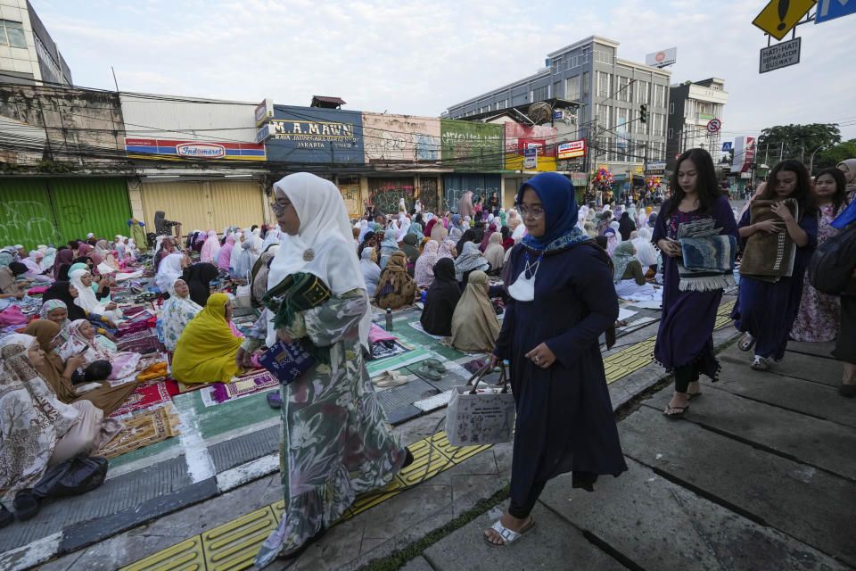 Muslims arrive for a morning prayer marking the Eid al-Adha holiday on a street in Jakarta, Indonesia, Thursday, June 29, 2023. Muslims around the world will celebrate Eid al-Adha, or the Feast of the Sacrifice, slaughtering sheep, goats, cows and camels to commemorate Prophet Abraham's readiness to sacrifice his son Ismail on God's command. (AP Photo/Tatan Syuflana)