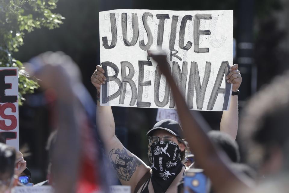 A protester holds a sign during a protest in Louisville, Ky., over the deaths of George Floyd and Breonna Taylor.