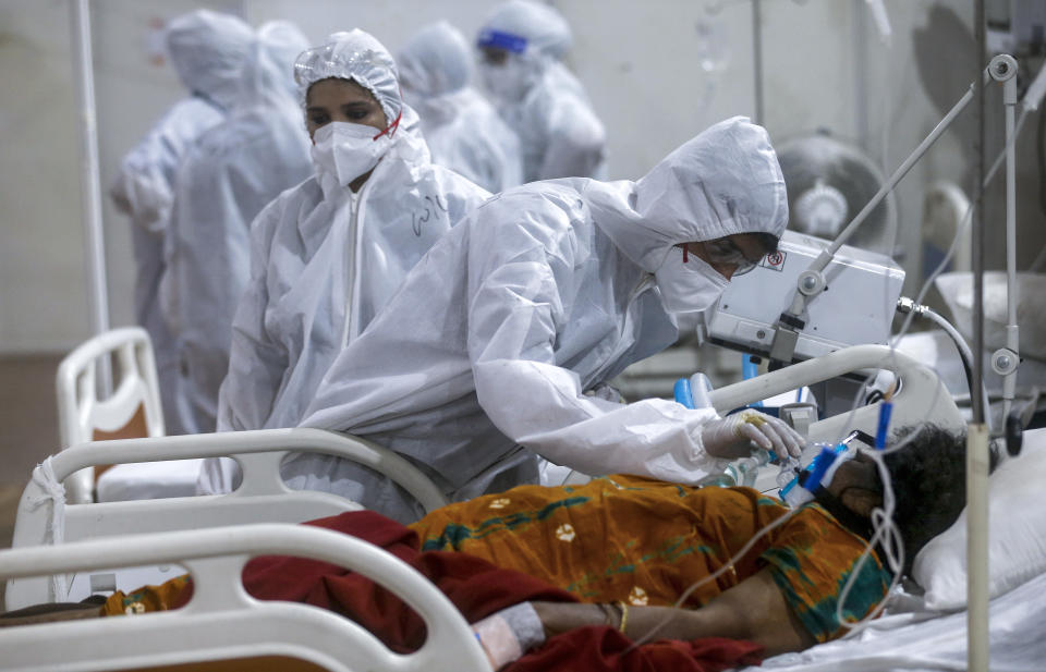 A health worker tries to adjust the oxygen mask of a patient at the BKC jumbo field hospital, one of the largest COVID-19 facilities in Mumbai, India, Thursday, May 6, 2021.(AP Photo/Rafiq Maqbool)