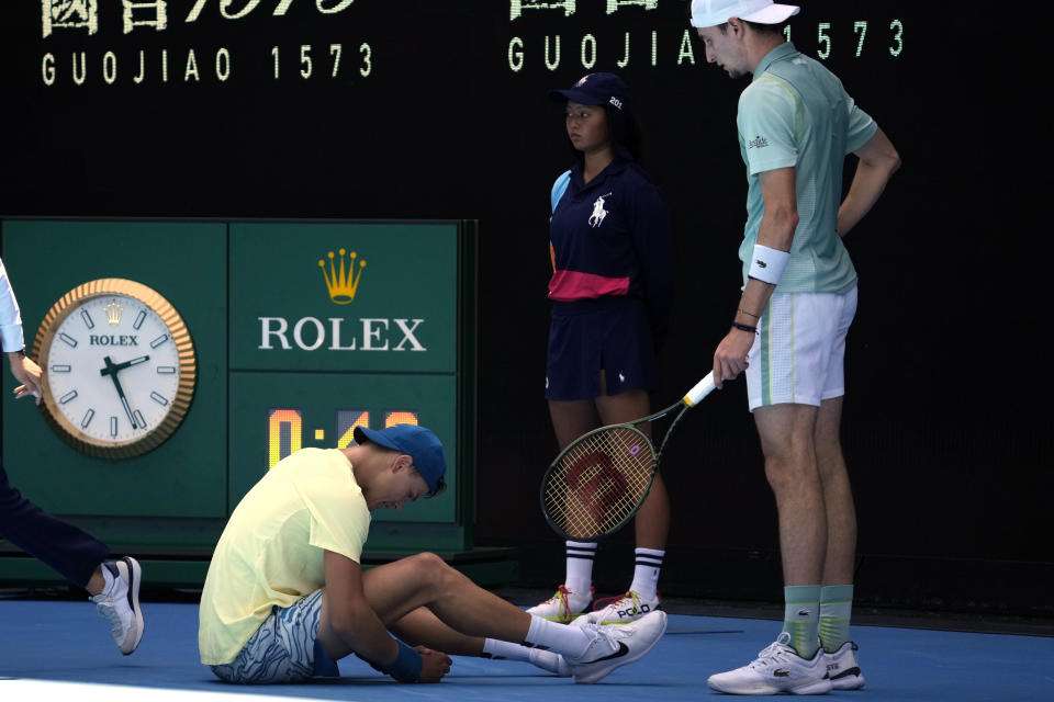 Ugo Humbert, right, of France checks on Holger Rune of Denmark after a fall during their third round match at the Australian Open tennis championship in Melbourne, Australia, Saturday, Jan. 21, 2023. (AP Photo/Dita Alangkara)