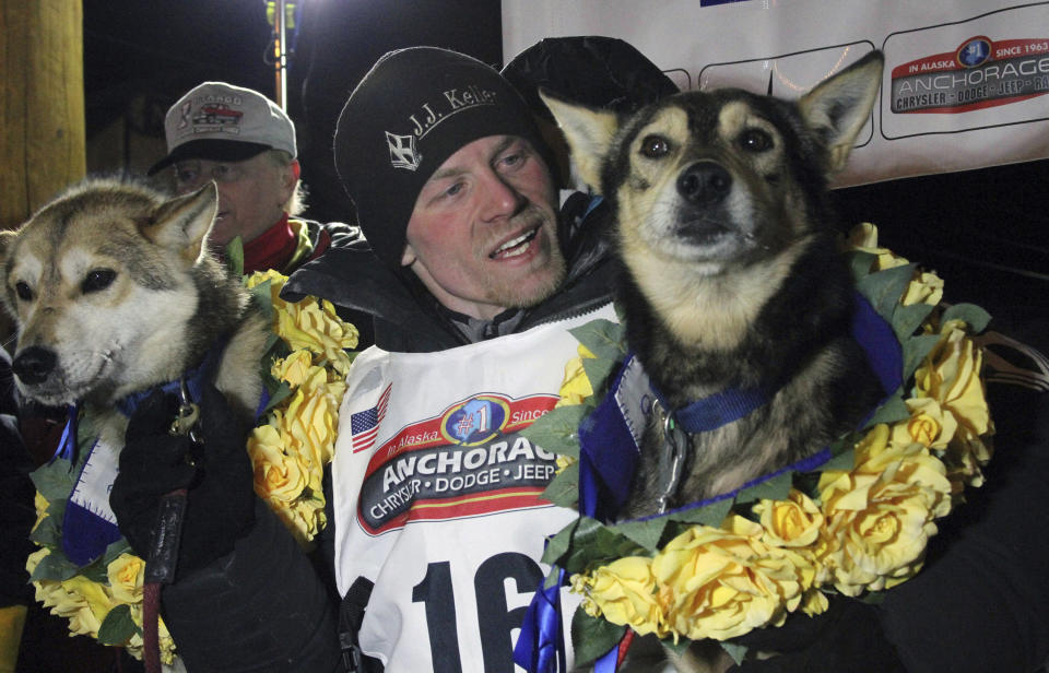 FILE - In this March 15, 2016 photo, Dallas Seavey poses with his lead dogs Reef, left, and Tide after finishing the Iditarod Trail Sled Dog Race in Nome, Alaska. Seavey is tied with musher Rick Swenson for the most Iditarod victories ever at five, and Seavey is looking for his sixth title when the Iditarod Trail Sled Dog Race starts this Saturday, March 5, 2022, in Alaska. (AP Photo/Mark Thiessen, File)