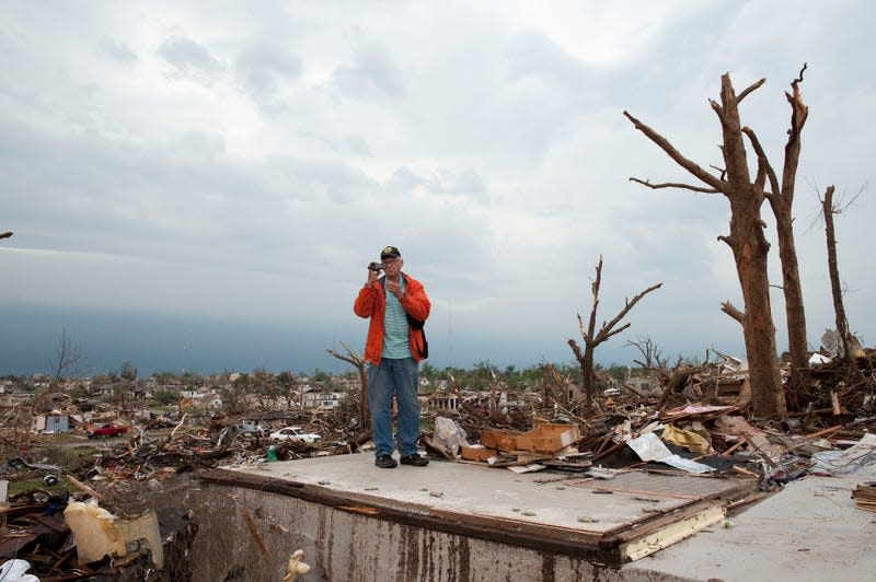 Jim Martin videotapes the damage as he and his wife attempt to salvage medication from her brother’s home before a second storm moves in, on May 23, 2011 in Joplin, Missouri. 
