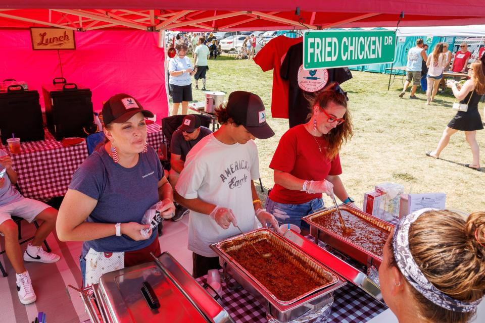 Amber Golden, left, owner of Clair's Family Restaurant, speaks with patrons as Ty Hoffman, center, and Kimberle Miller, right, prepare samples of the restaurant's chili during the 27th annual Hanover Chili Cookoff Sunday.