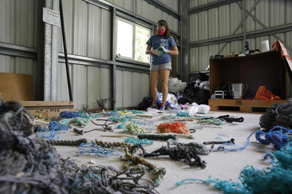 Jennifer Lynch, a research scientist at the National Institute of Standards and Technology and the co-director of Hawaii Pacific University's Center for Marine Debris Research, catalogs pieces of ghost nets on Wednesday, May 12, 2021 in Kaneohe, Hawaii. Researchers are conducting a study that will attempt to trace derelict fishing gear that washes ashore in Hawaii back to the manufacturers and fisheries that it came from. (AP Photo/Caleb Jones)